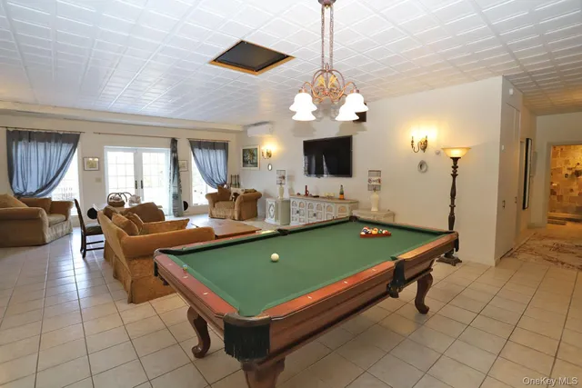 a room with pool table and windows