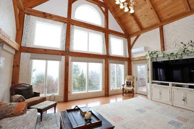 a living room with furniture a flat screen tv and a floor to ceiling window