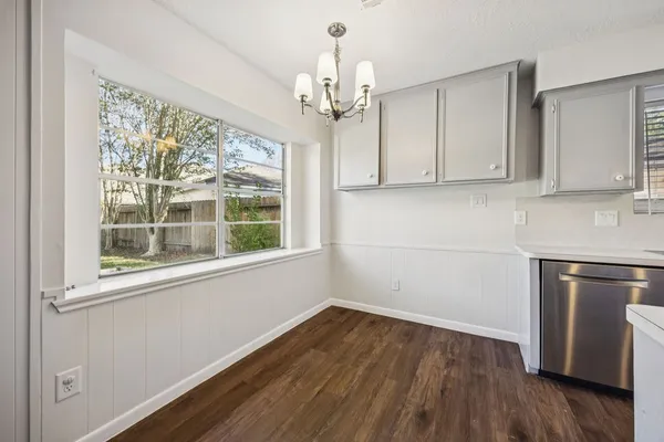 a kitchen with a wooden floor and a window
