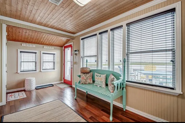a bedroom with a bed a chair and next to a window