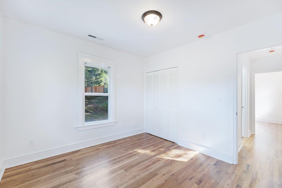 225 Owl Ridge Way Aptos, CA 95003 - Photo 18 of 26 an empty room with wooden floor and windows