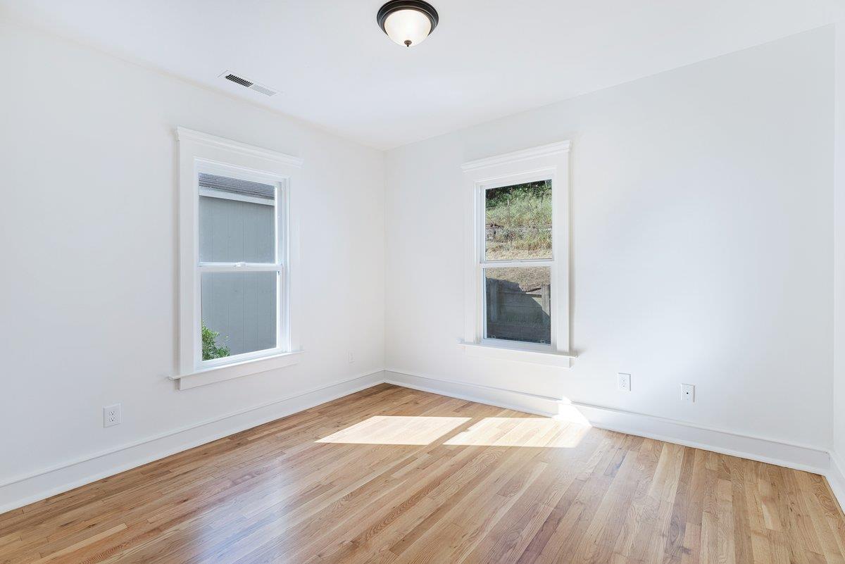 225 Owl Ridge Way Aptos, CA 95003 - Photo 21 of 26 an empty room with wooden floor and windows