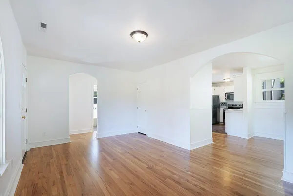 a view of empty room with wooden floor