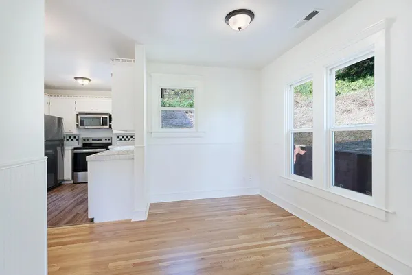 a kitchen with granite countertop stainless steel appliances a refrigerator microwave and stove top oven