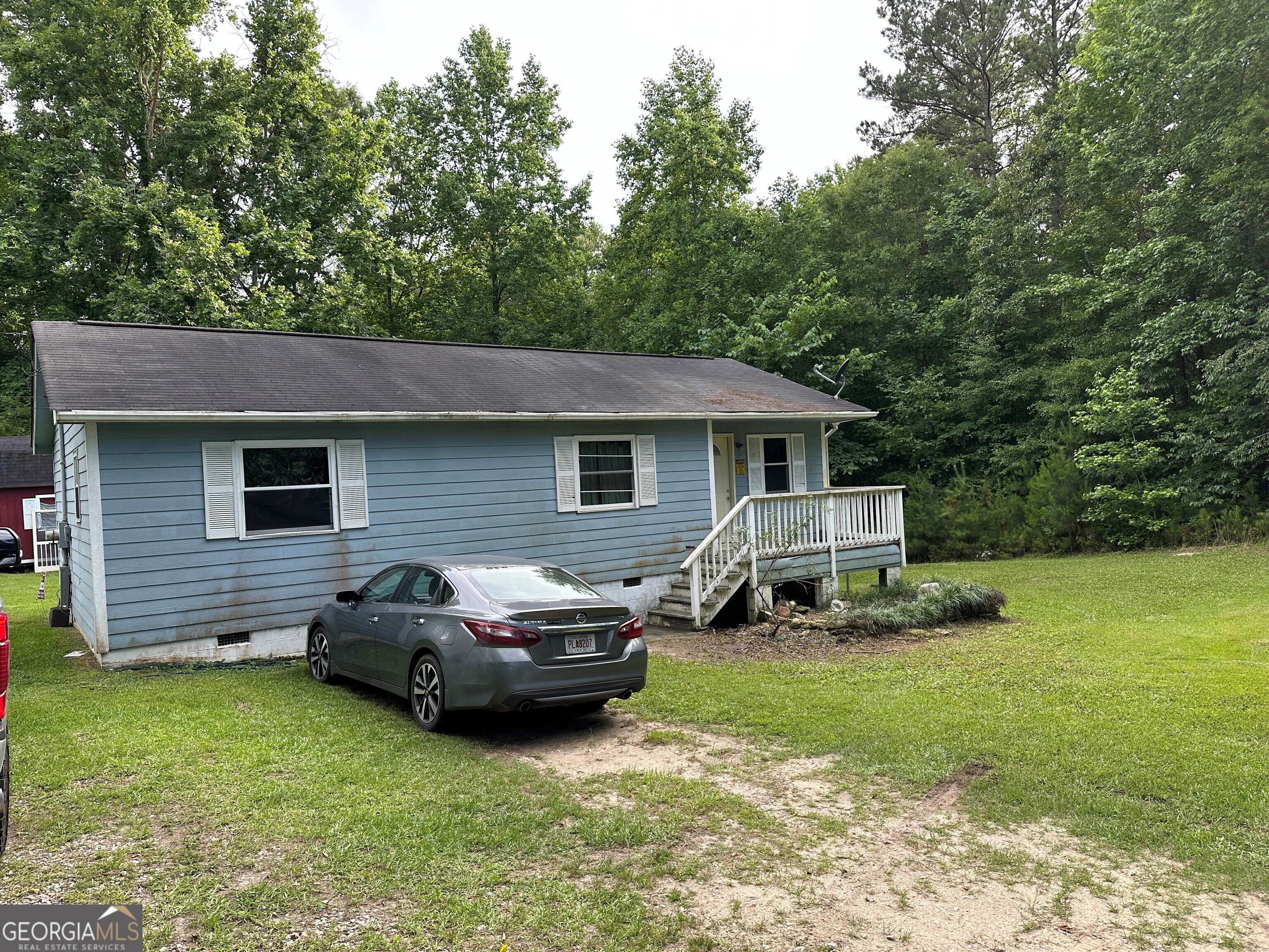 a car parked in front of a house and a yard