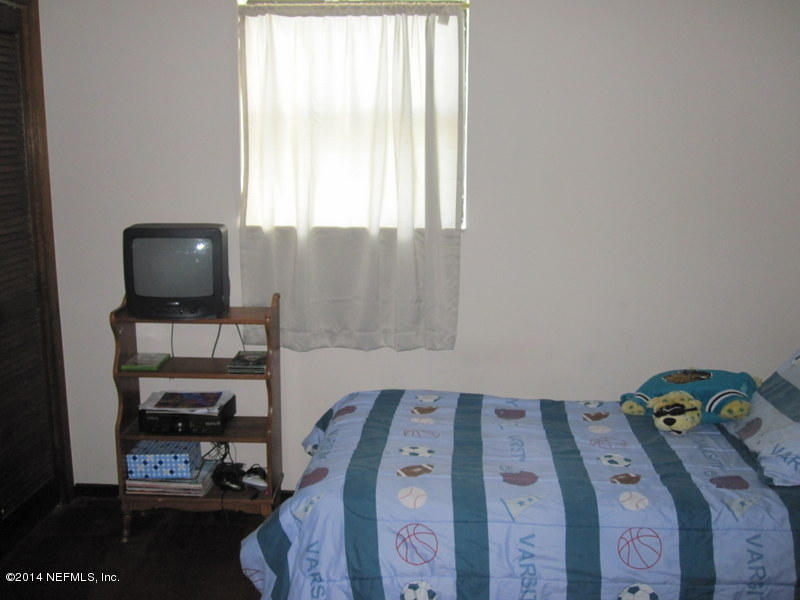 11440 Scott Mill Road Jacksonville, FL 32223 - Photo 15 of 26 a bedroom with a bed and a window