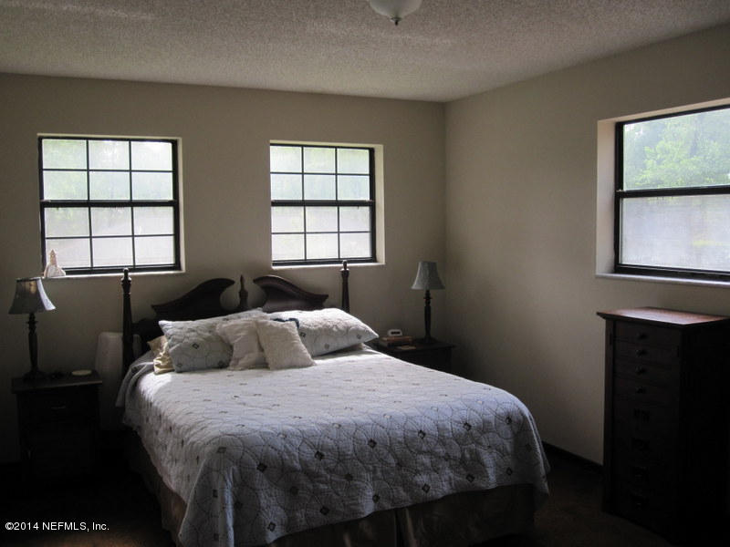 11440 Scott Mill Road Jacksonville, FL 32223 - Photo 16 of 26 a bedroom with a bed and window