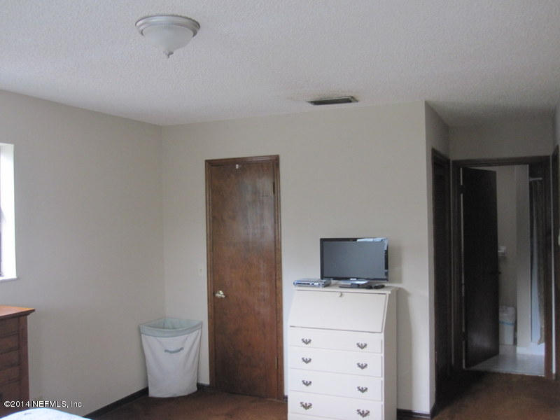 11440 Scott Mill Road Jacksonville, FL 32223 - Photo 17 of 26 a room with a bed and a television