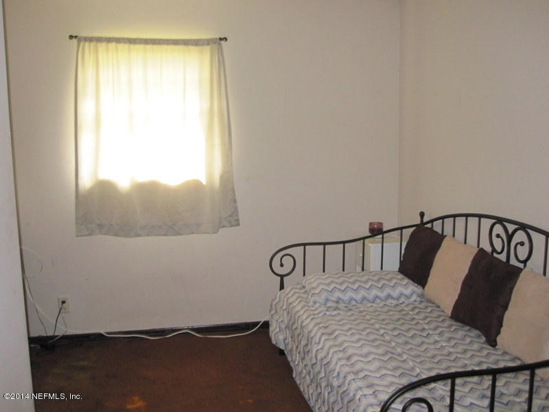 11440 Scott Mill Road Jacksonville, FL 32223 - Photo 18 of 26 a bedroom with a bed and window