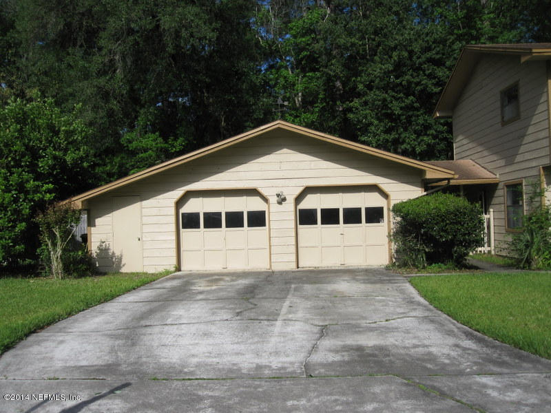 11440 Scott Mill Road Jacksonville, FL 32223 - Photo 3 of 26 a white house with a small yard plants and large trees