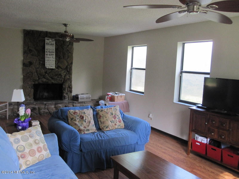 11440 Scott Mill Road Jacksonville, FL 32223 - Photo 6 of 26 a living room with furniture a flat screen tv and a fireplace