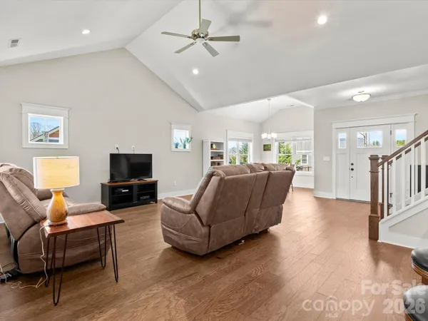 a living room with furniture a ceiling fan and a flat screen tv