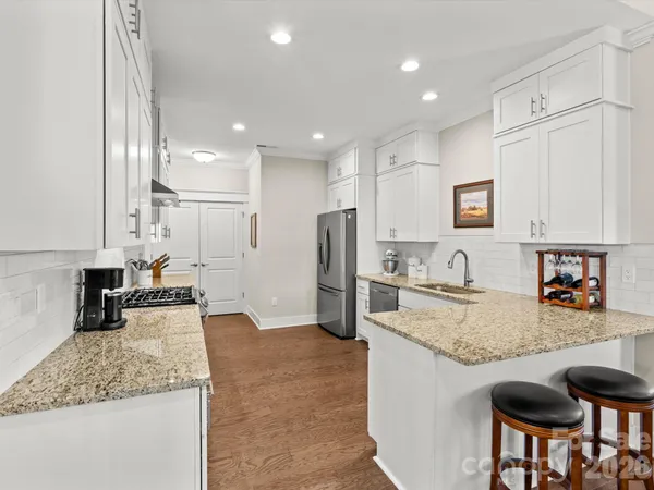 a kitchen with stainless steel appliances granite countertop a sink refrigerator and cabinets