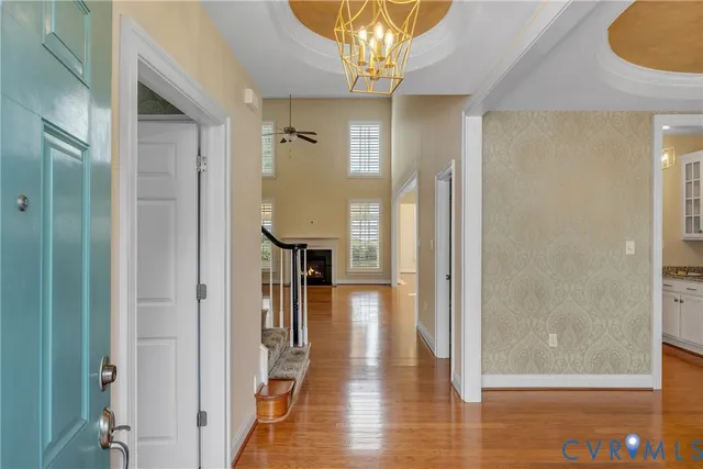 a view of a hallway with wooden floor and a dining room