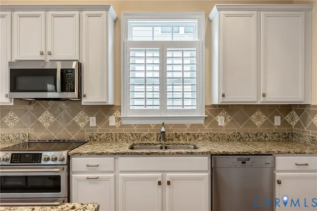a kitchen with stainless steel appliances granite countertop a refrigerator sink and cabinets