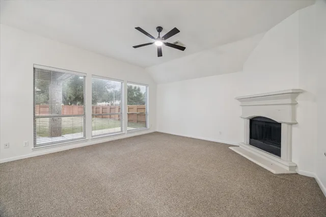 a view of an empty room with a fireplace and a window