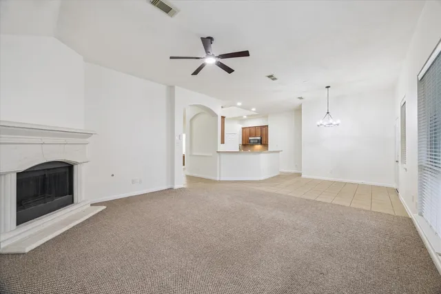 a view of a livingroom with a ceiling fan a fireplace and window