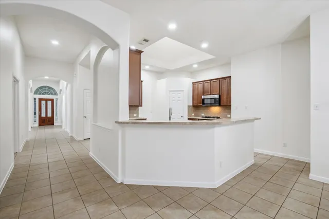 a view of kitchen with stainless steel appliances cabinets and window