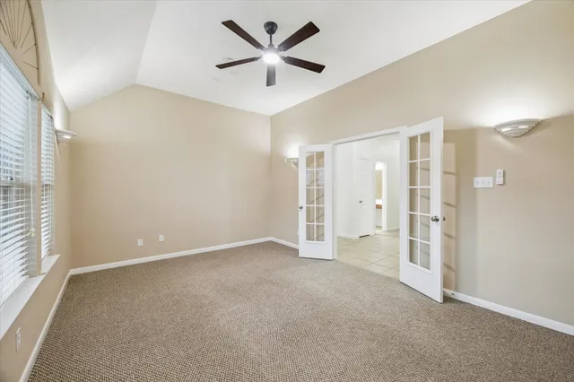 an empty room with a ceiling fan and a window