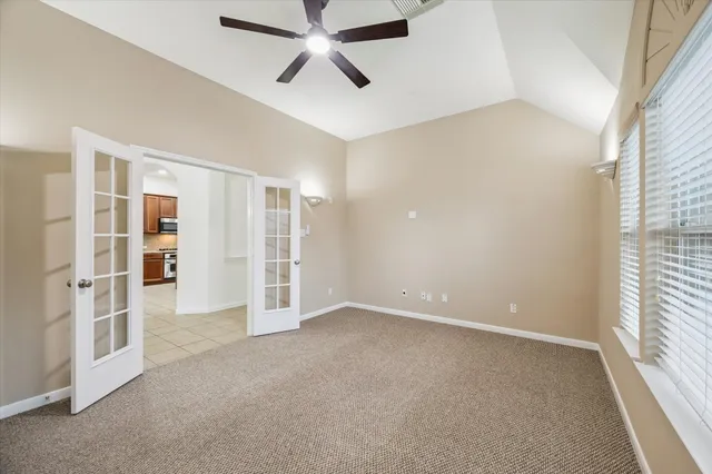 an empty room with a window and a ceiling fan