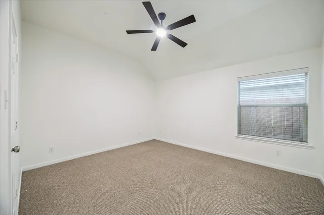 an empty room with a window and a fan