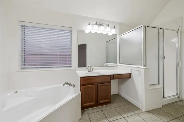 a bathroom with a tub sink and mirror