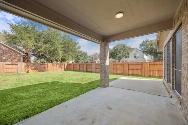 a view of a house with a big yard potted plants and large tree