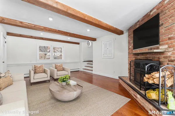 a kitchen with stainless steel appliances granite countertop a refrigerator a stove a sink and white cabinets with wooden floor