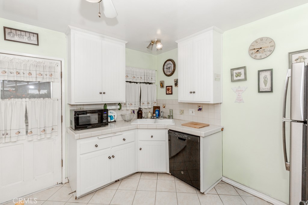 4151 Manchester Place Riverside, CA 92503 - Photo 12 of 36 a kitchen with a sink a stove top oven and white cabinets