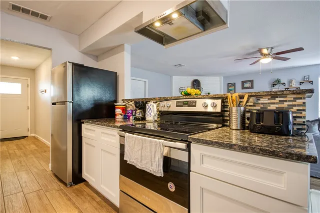 a kitchen with stainless steel appliances granite countertop a stove and a refrigerator