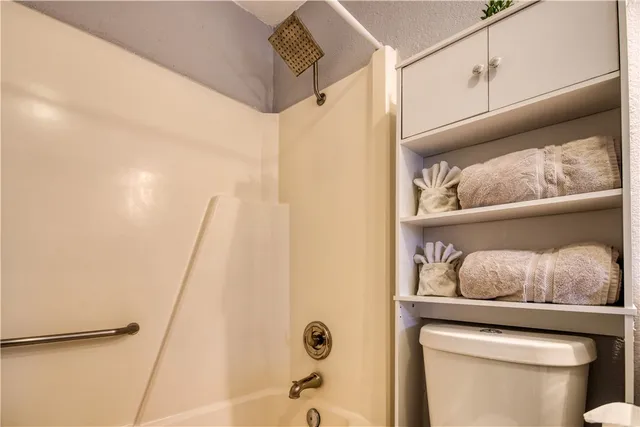a bathroom with a toilet and shower