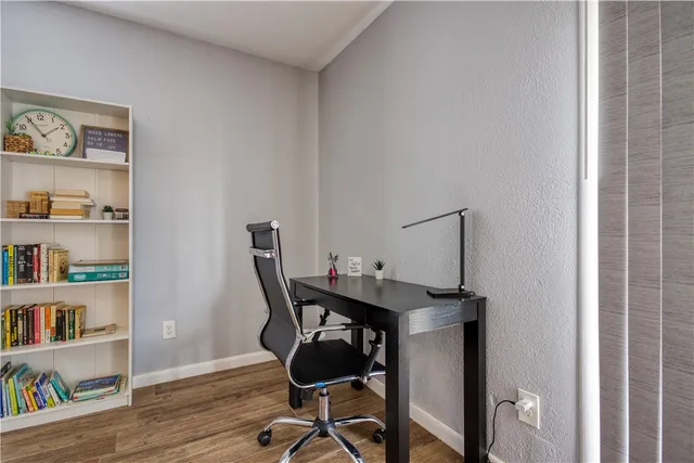 a view of a workspace with furniture and wooden floor