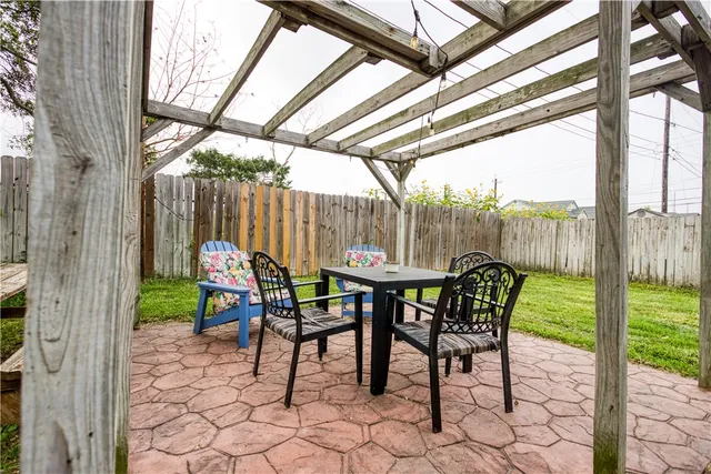 a view of a patio with a table chairs and a backyard