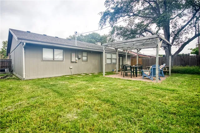 a backyard of a house with table and chairs