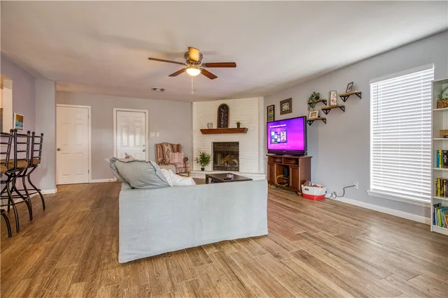 a living room with fireplace furniture and a wooden floor