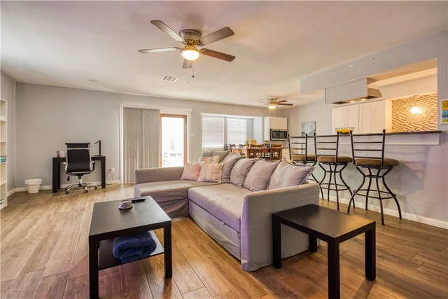 a living room with furniture and a wooden floor