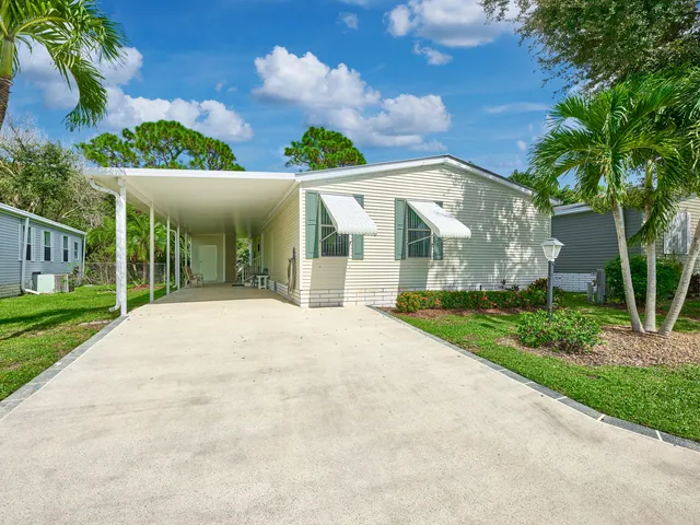 a view of a white house with a yard and plants