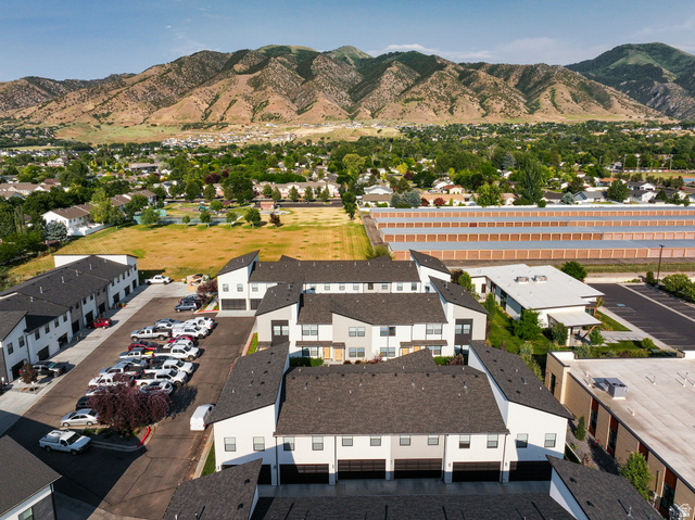 220 Spring Creek Parkway Providence, UT 84332 - Photo 12 of 26 Modern townhome development featuring white and gray exteriors, dark shingle roofing, and integrated garage doors