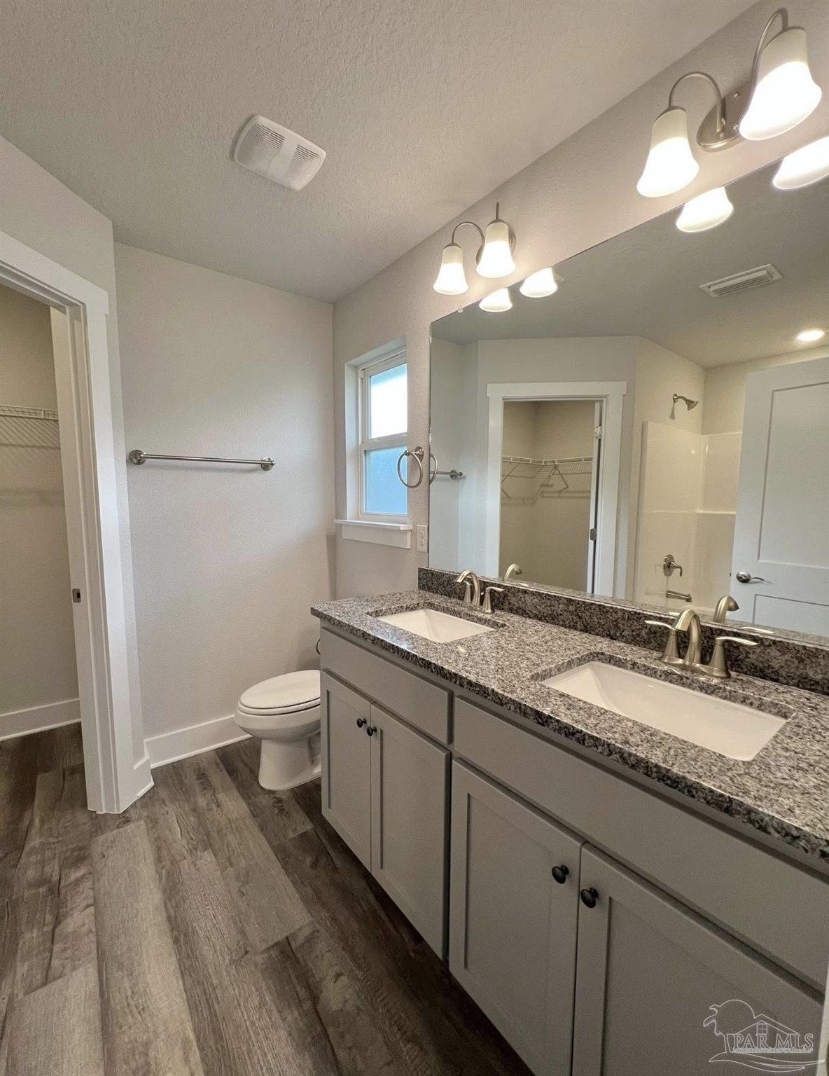 1766 Leigh Loop, Unit 3D Cantonment, FL 32533 - Photo 6 of 8 a bathroom with a granite countertop sink mirror and toilet