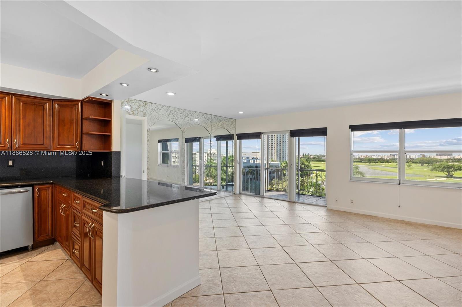 200 Diplomat Parkway, Unit 825 Hallandale Beach, FL 33009 - Photo 11 of 29 a kitchen with granite countertop a sink and a stove