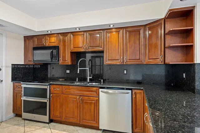 a kitchen with stainless steel appliances granite countertop a sink stove and cabinets