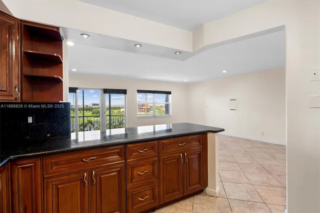 a kitchen with granite countertop a sink and a wooden cabinets