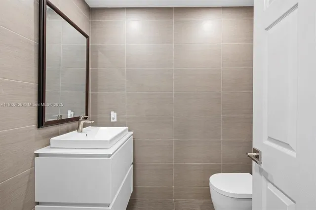 a bathroom with a sink a toilet and a mirror