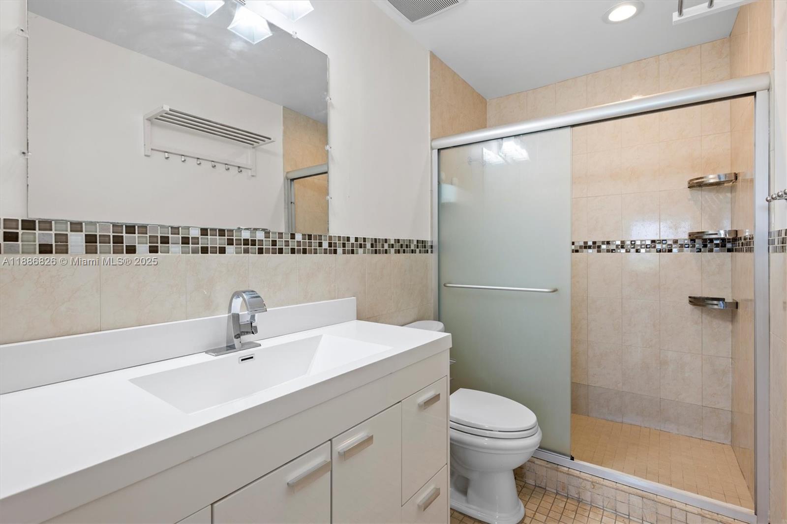 200 Diplomat Parkway, Unit 825 Hallandale Beach, FL 33009 - Photo 19 of 29 a bathroom with a sink a mirror a toilet and shower