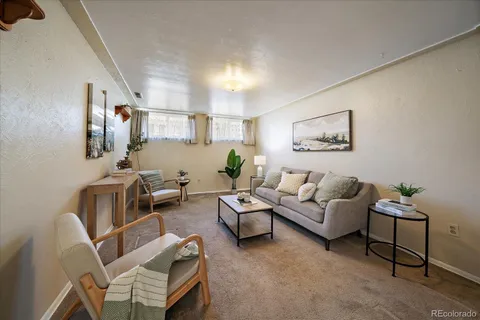a living room with furniture and a painting on the wall