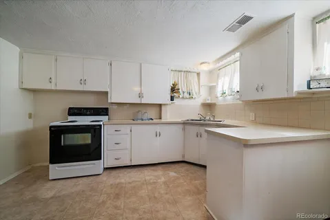 a kitchen with granite countertop white cabinets and stainless steel appliances