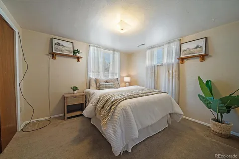 a spacious bedroom with a bed and a potted plant