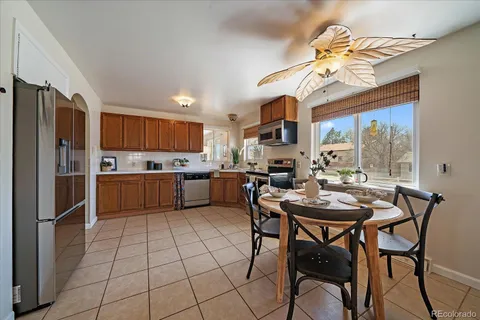 a kitchen with stainless steel appliances a table and chairs in it