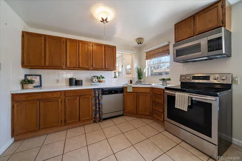a kitchen with stainless steel appliances granite countertop a sink dishwasher stove and microwave with cabinets