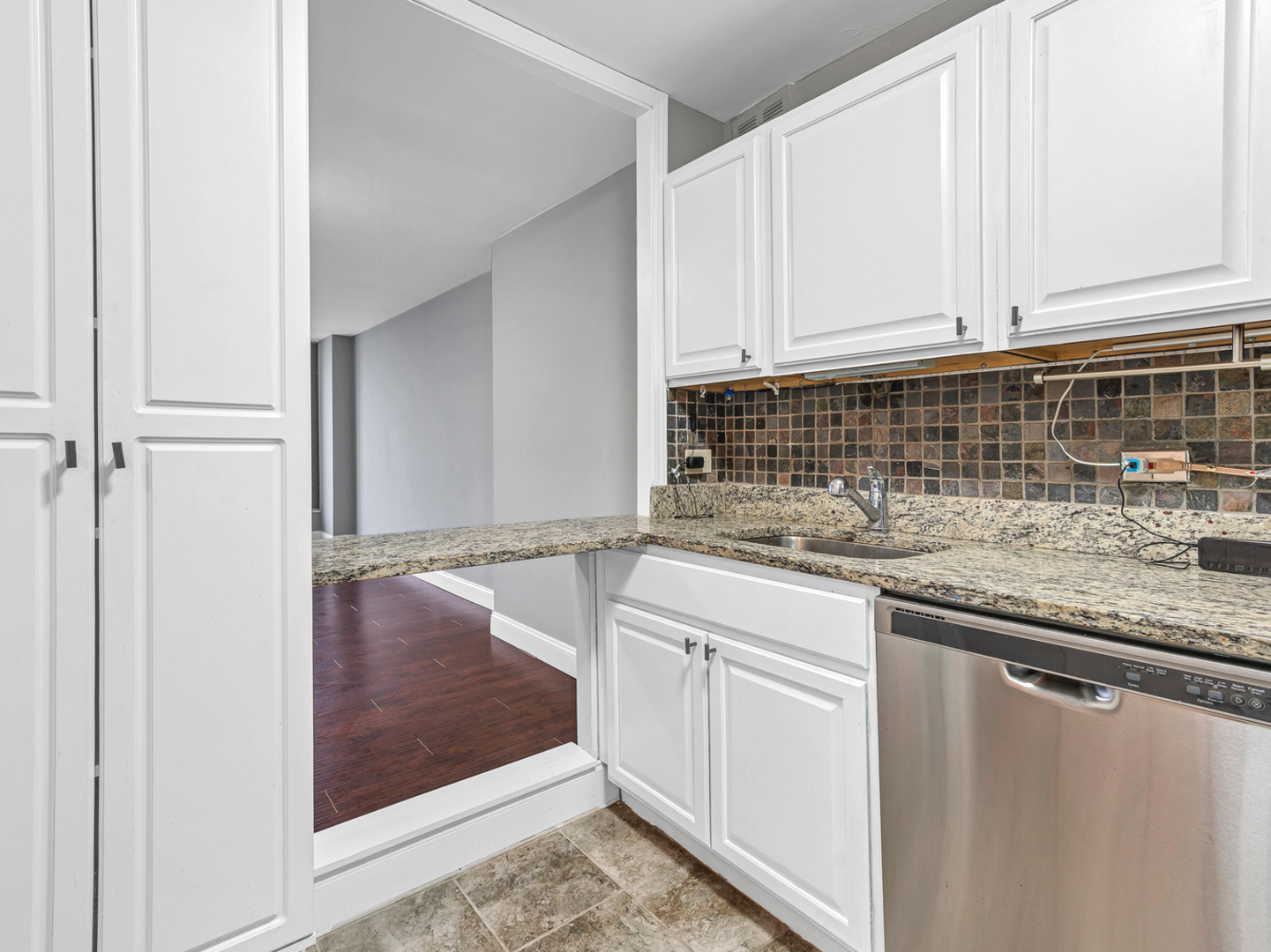 5415 North Sheridan Road, Unit 5409 Chicago, IL 60640 - Photo 12 of 37 a kitchen with granite countertop a sink and cabinets